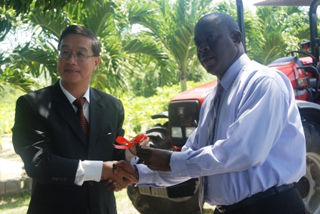 (L-R) Ambassador of the Republic of China/Taiwan to St. Kitts and Nevis His Excellency Miguel Tsao handing over the keys to a new Massey Ferguson tractor to Minister of Agriculture on Nevis Hon. Robelto Hector at the Taiwanese Mission at Cades Bay